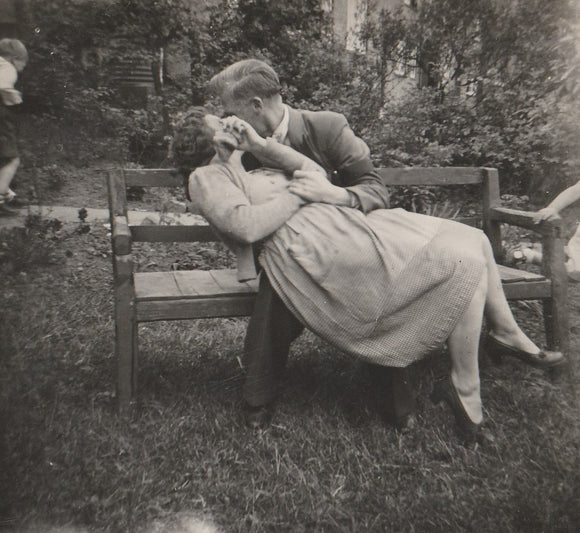 Young woman on a bench being kissed