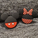 A pair of silicone stitch stoppers, the first of which is shaped as the iconic black, three circled mouse head with the bottom half of the main circle is red with two white circle buttons.  The second is the same black, three circled mouse head with the bottom half of the main circle red with white polka dots, and with a large bow between the ears in red with white polka dots.  