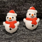 Two silicone stitch stoppers in the shape of small snowmen wearing red scarves and santa hats.  