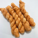 4 mini skeins of a pale peachy tonal orange coloured yarn.