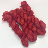 Four mini skeins of tonal red yarn. 