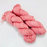 Two mini skeins of pale pink worsted weight yarn. 