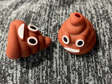 Two three dimensional silicone stitch stoppers in the form of brown swirls with smiling faces, the 3D image of the poop emoji.  One is lay down and the other is stood up.  