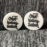 Two silicone stitch stoppers in the form of white discs with the words "Not today satan" in black on them, surrounded by black "sparkles".