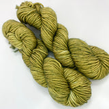 Two mini skeins of mossy green tonal worsted weight yarn. 