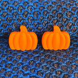 Two silicon stitch stoppers in the form of orange pumpkins.